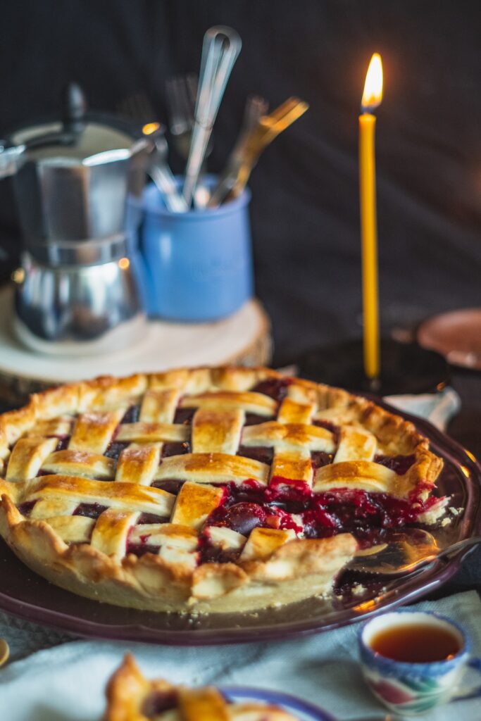 Foto in cui è rappresentata una crostata di ciliegie in cui manca una fetta, in modo da far vedere l'interno.